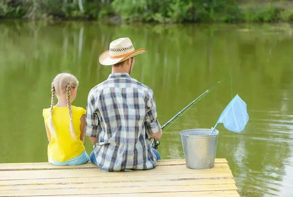 petite fille qui pêche dans le lac avc son papa